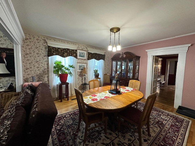344 Main St, Lincoln, ME 04457 - dining space with crown molding, wallpapered walls, and light wood-type flooring
