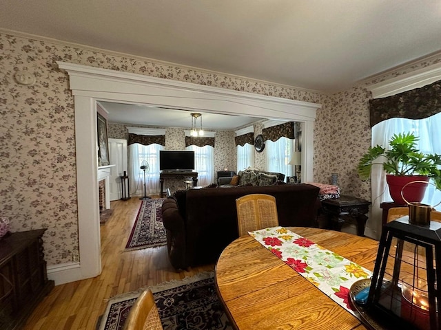 344 Main St, Lincoln, ME 04457 - dining room featuring wallpapered walls, ornamental molding, baseboards, and light wood-type flooring
