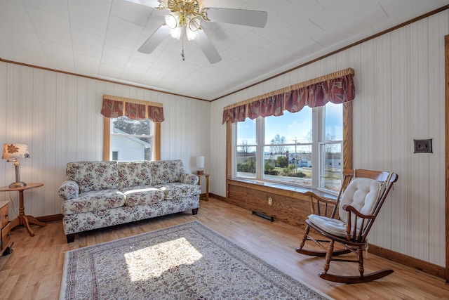 living room with plenty of natural light, ornamental molding, and wood finished floors