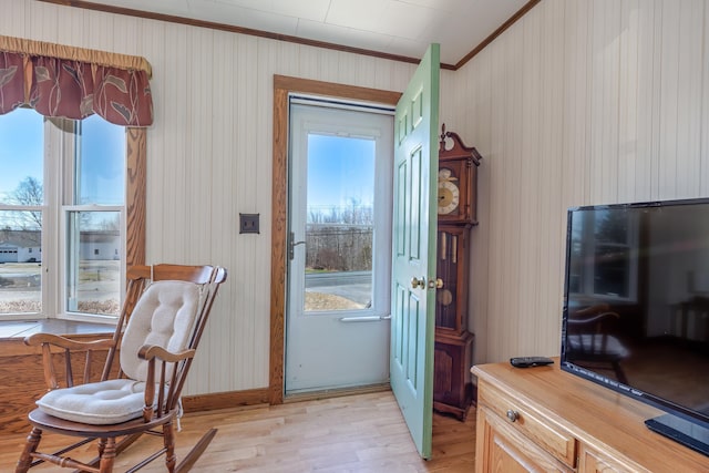 entryway featuring crown molding, plenty of natural light, and light wood-type flooring