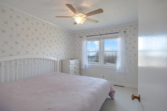 carpeted bedroom featuring wallpapered walls, ornamental molding, and ceiling fan