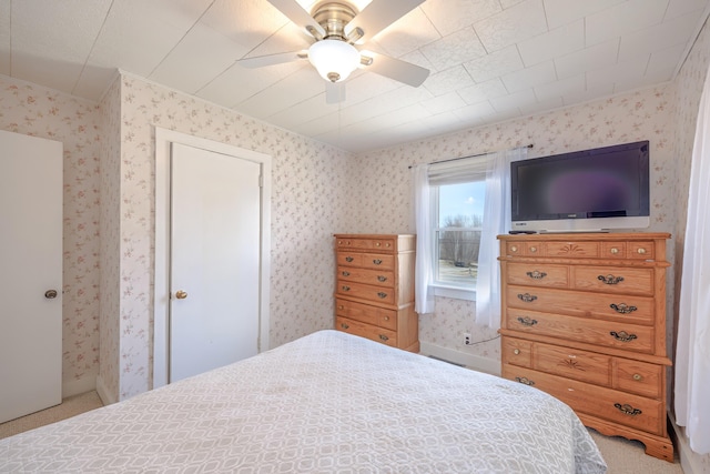 bedroom with wallpapered walls and ceiling fan