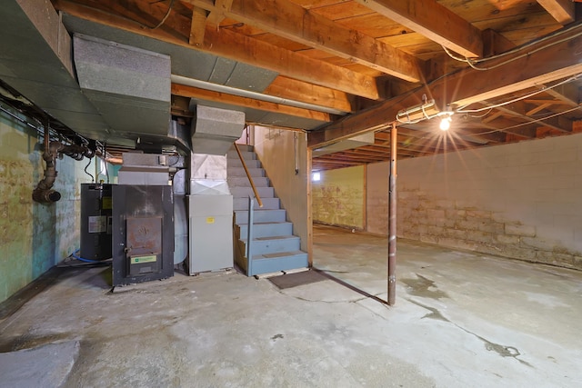 unfinished below grade area featuring stairway and electric water heater