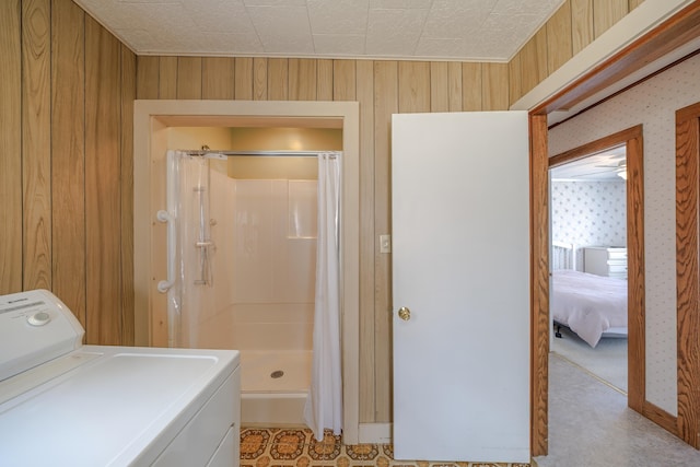 laundry room featuring washer / dryer, baseboards, laundry area, and wooden walls