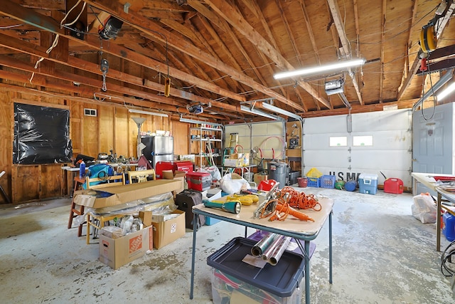 garage with freestanding refrigerator and a garage door opener