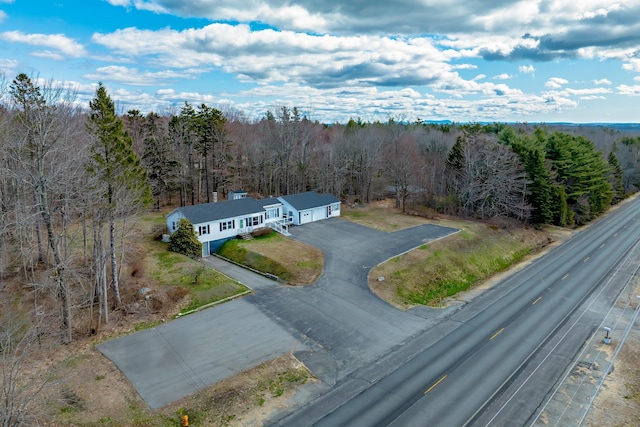 drone / aerial view featuring a wooded view