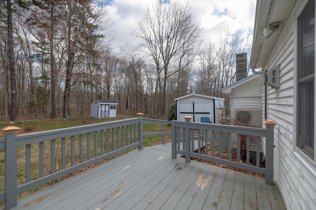 wooden terrace with ac unit, a shed, and an outbuilding