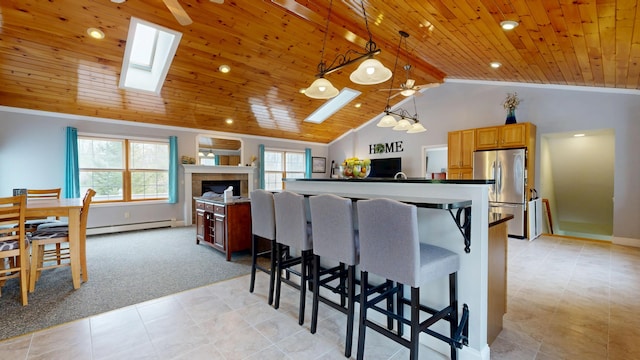 kitchen featuring wood ceiling, freestanding refrigerator, open floor plan, vaulted ceiling with skylight, and light colored carpet