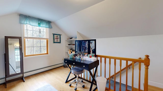 home office with a baseboard heating unit, lofted ceiling, and wood finished floors
