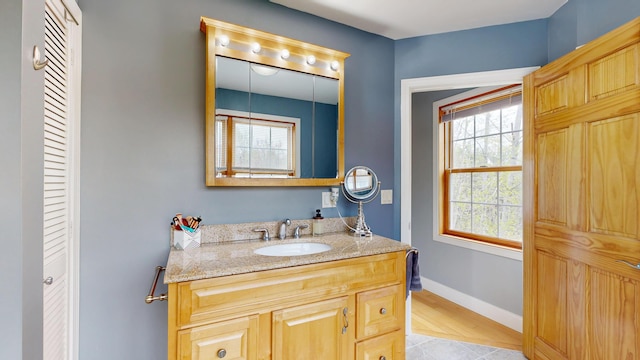 bathroom with vanity, tile patterned flooring, and baseboards