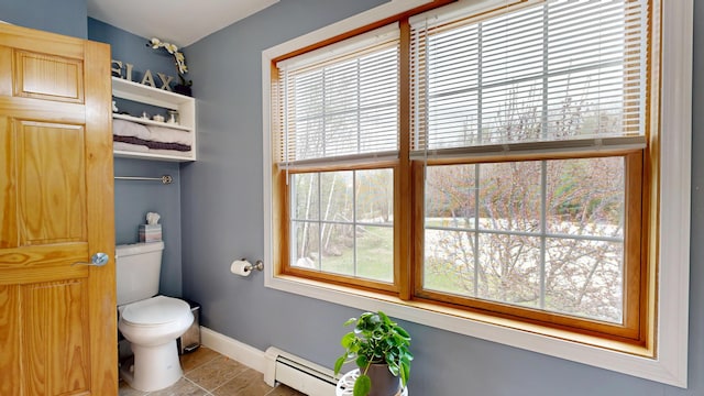 bathroom with baseboard heating, toilet, and baseboards