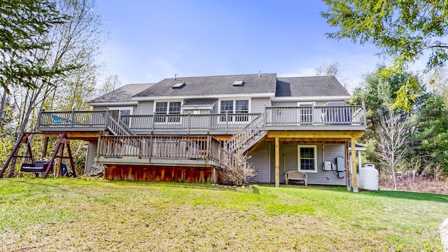 back of house featuring stairway, a deck, and a lawn