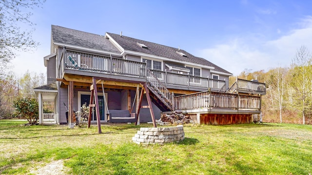 back of property featuring a deck, a lawn, stairs, and a shingled roof