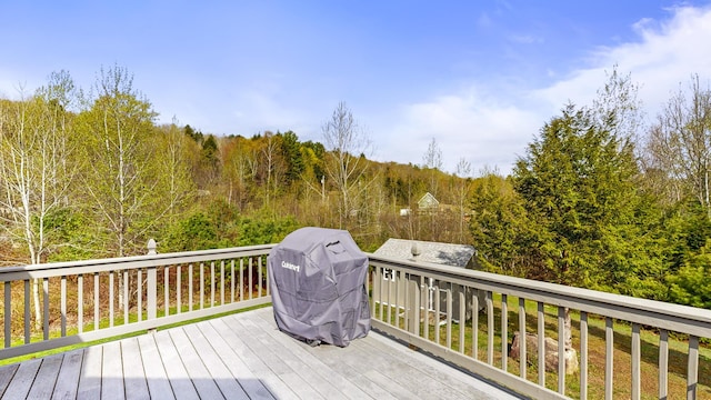 wooden deck featuring area for grilling and a forest view