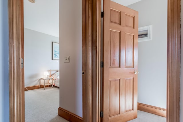 corridor with carpet flooring and baseboards