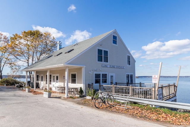 view of front facade featuring a water view and a shingled roof