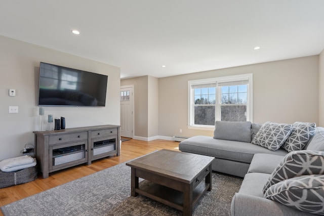 living area featuring recessed lighting, a baseboard radiator, light wood finished floors, and a wealth of natural light