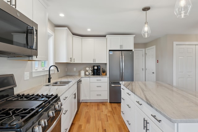 kitchen featuring recessed lighting, light wood-type flooring, white cabinetry, a sink, and appliances with stainless steel finishes