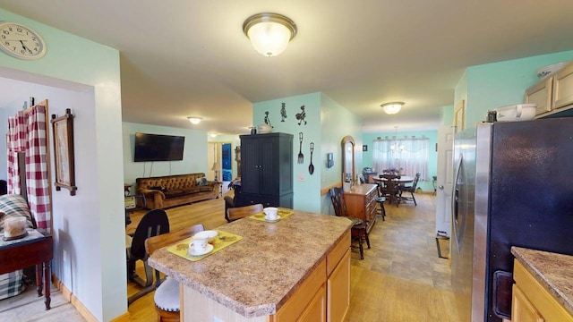242 Bottle Lake Rd, Springfield, ME 04487 - kitchen featuring a kitchen island, light countertops, freestanding refrigerator, open floor plan, and an inviting chandelier