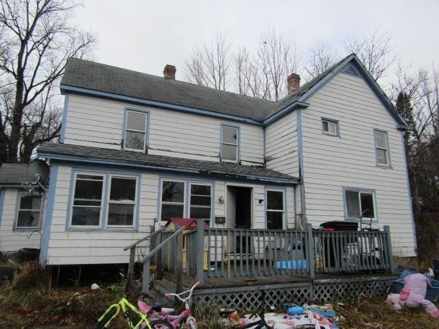 back of house featuring a chimney and a deck