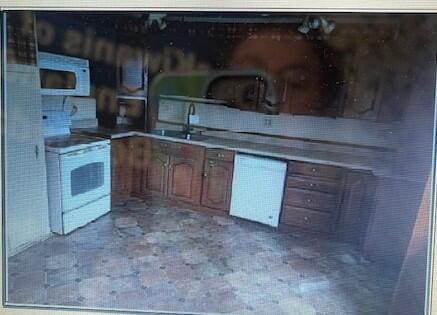 kitchen featuring a sink and white appliances