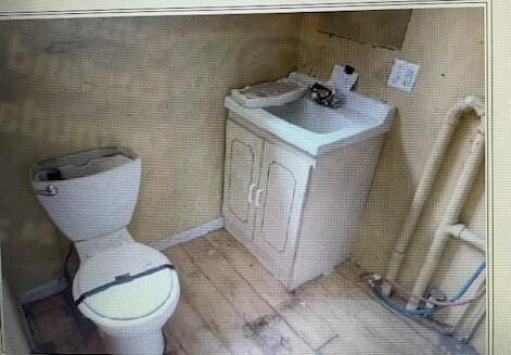 half bathroom with vanity, tile patterned flooring, and toilet