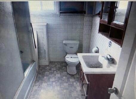 full bath with vanity, shower / washtub combination, toilet, and tile walls