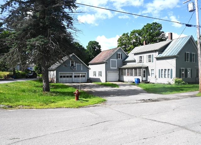 12 Preble St, Bingham, ME 04920 - view of front of house with a standing seam roof, a metal roof, a front lawn, a chimney, and asphalt driveway