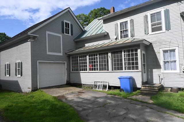 12 Preble St, Bingham, ME 04920 - view of front of home featuring a standing seam roof, driveway, a garage, a chimney, and a metal roof