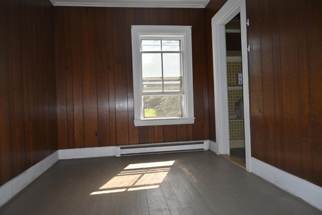 12 Preble St, Bingham, ME 04920 - unfurnished room featuring a baseboard radiator, plenty of natural light, wooden walls, and hardwood / wood-style flooring