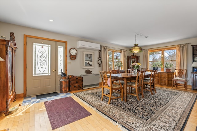 dining space featuring baseboards, a wall mounted AC, recessed lighting, and light wood-style flooring