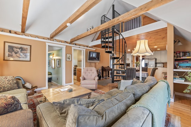 living room featuring beam ceiling, baseboards, high vaulted ceiling, light wood finished floors, and stairs