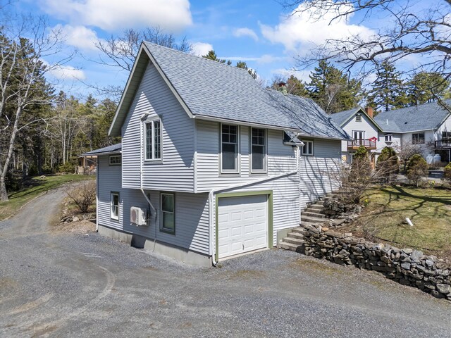 view of side of home with roof with shingles, dirt driveway, a chimney, and an attached garage