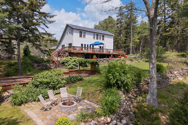 33 Taylor Rd, Westport Island, ME 04578 - rear view of property featuring a deck, a fire pit, a patio, a lawn, and stairs