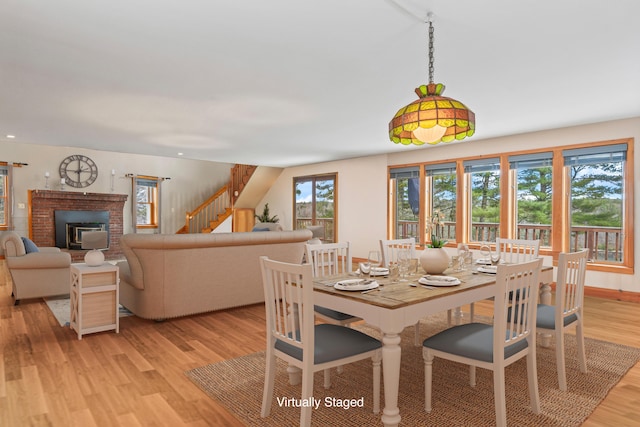 33 Taylor Rd, Westport Island, ME 04578 - dining space with light wood-style floors, stairs, and a brick fireplace