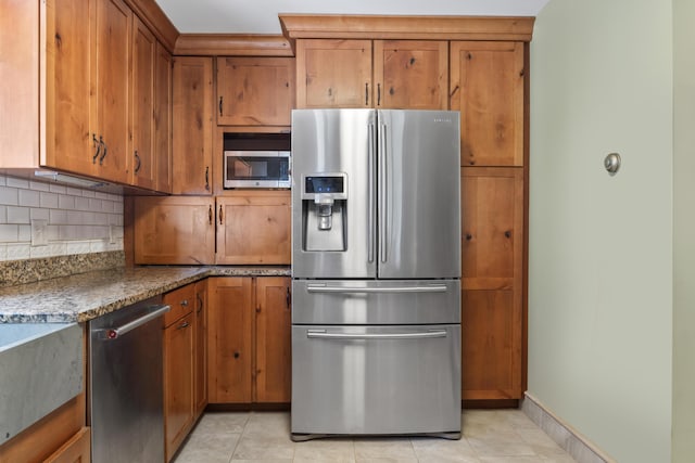 33 Taylor Rd, Westport Island, ME 04578 - kitchen featuring stainless steel appliances, brown cabinets, backsplash, and light tile patterned floors