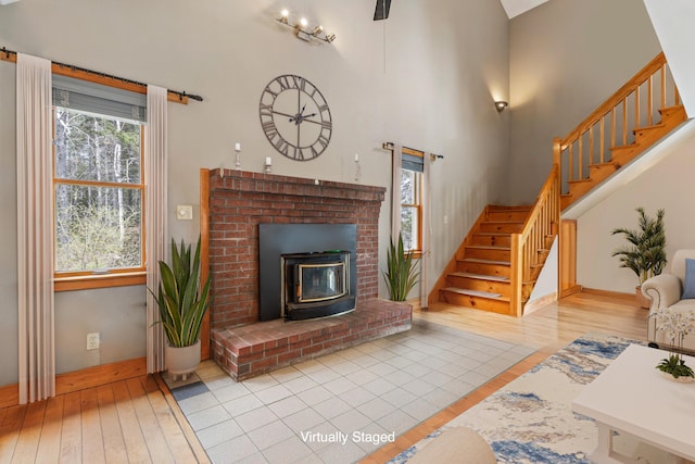 33 Taylor Rd, Westport Island, ME 04578 - living room with stairs, hardwood / wood-style floors, a wood stove, and a high ceiling