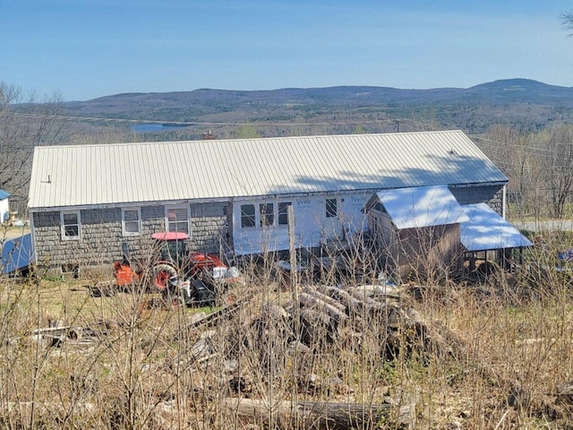 rear view of house with a mountain view and metal roof
