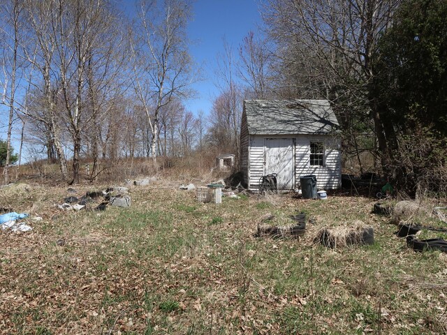 view of yard featuring a storage unit and an outbuilding