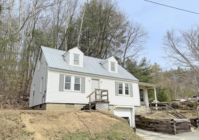 cape cod house with a garage and metal roof