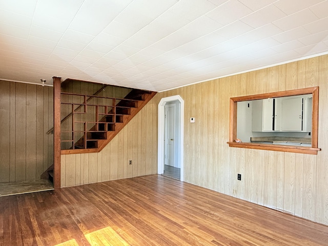 171 Granite St, Mexico, ME 04257 - unfurnished living room with wood walls, stairs, arched walkways, and wood finished floors