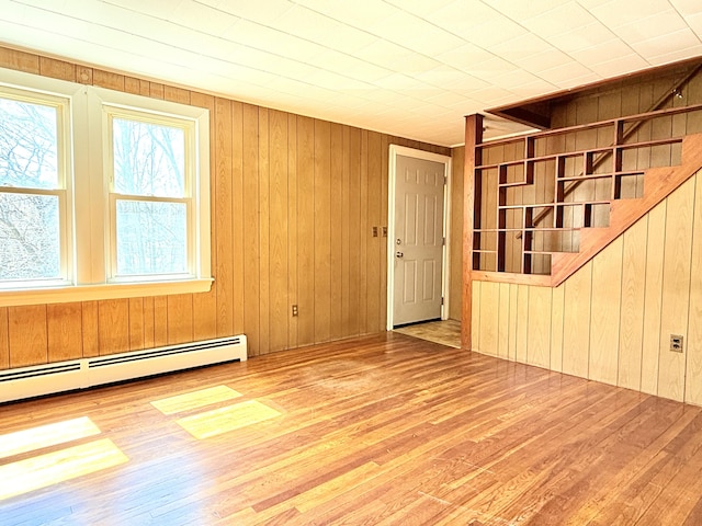 171 Granite St, Mexico, ME 04257 - empty room featuring stairway, wood walls, baseboard heating, and hardwood / wood-style flooring