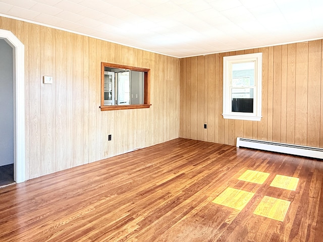171 Granite St, Mexico, ME 04257 - empty room with a baseboard radiator, arched walkways, wood finished floors, and wooden walls