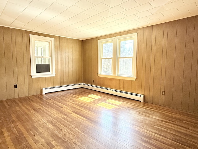 171 Granite St, Mexico, ME 04257 - unfurnished room featuring wood-type flooring, a baseboard heating unit, and wooden walls