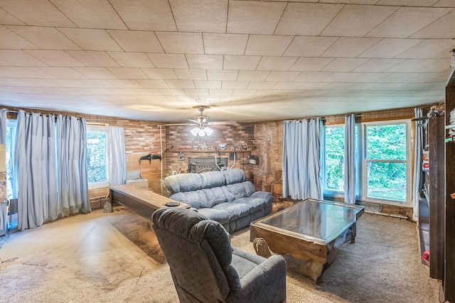 living area with carpet floors, ceiling fan, and a brick fireplace