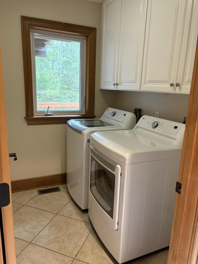 1 Mccracken Ln, Bristol, ME 04539 - washroom featuring washing machine and clothes dryer, cabinet space, baseboards, and light tile patterned flooring