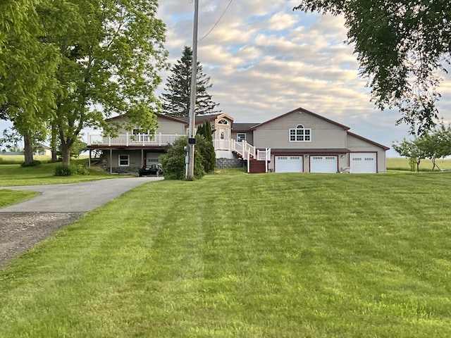 view of front facade featuring an attached garage, a front yard, and aphalt driveway