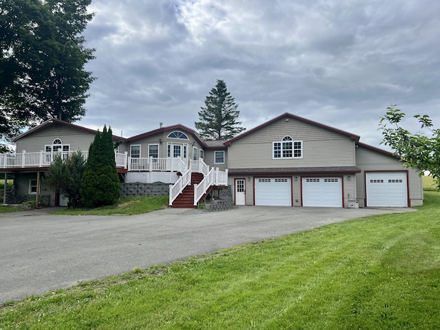 view of front of house with a garage, aphalt driveway, and a front yard
