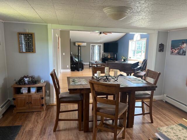 dining room featuring baseboards, ceiling fan, and wood finished floors