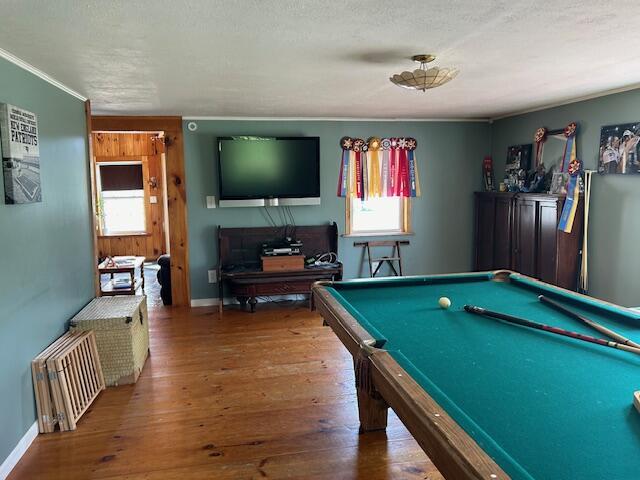 rec room with a textured ceiling, a wealth of natural light, and hardwood / wood-style floors